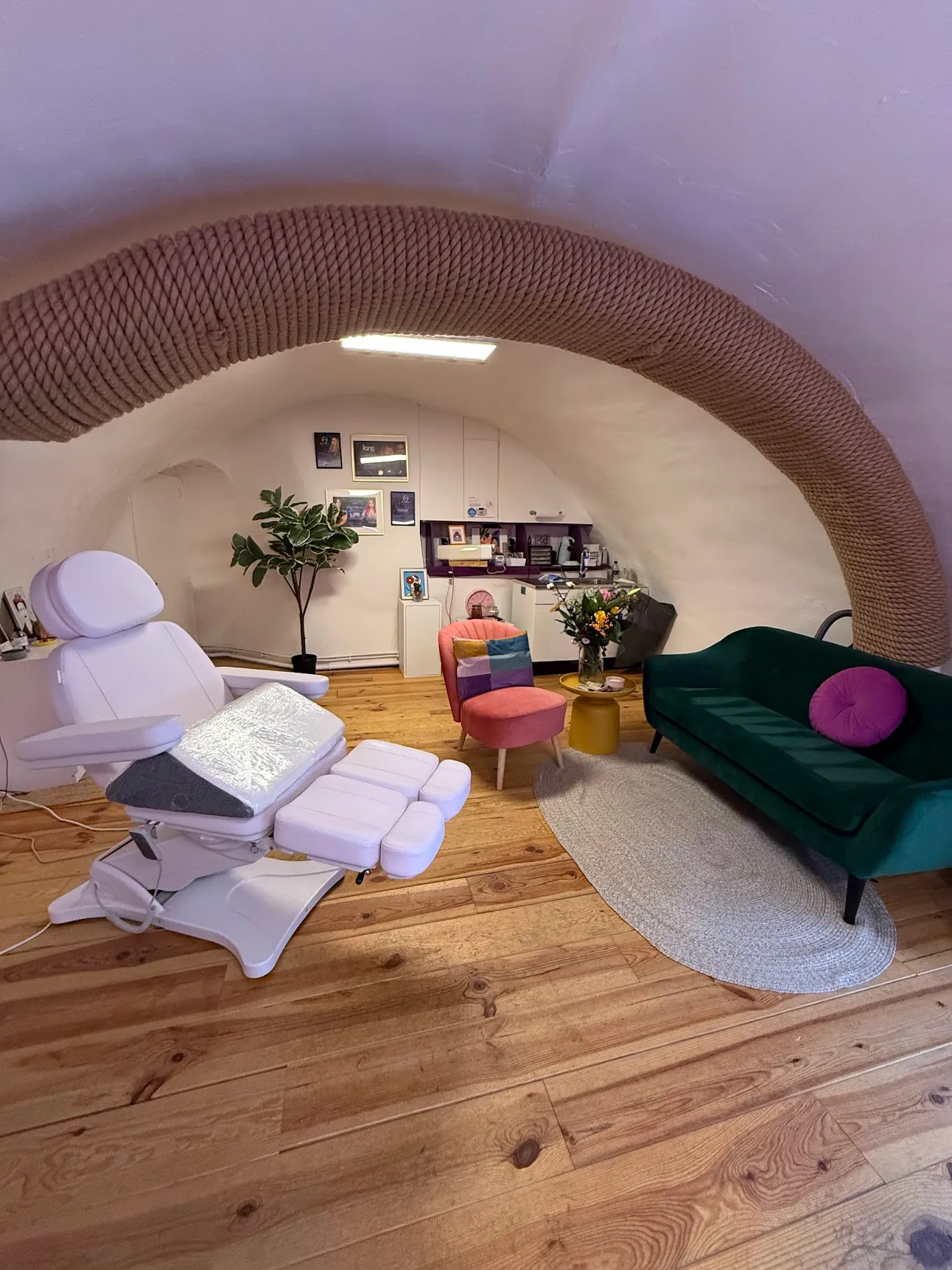 Treatment chair and green sofa under the vaulted ceiling of the studio